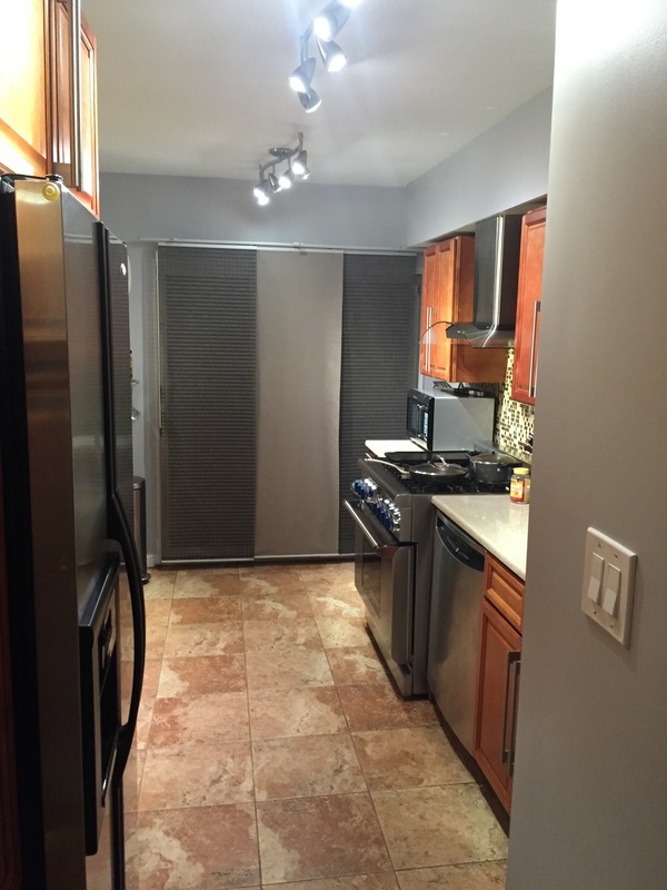 Before kitchen renovation featuring older appliances, warm wood cabinets, and a narrow layout with a closed-off cooking area.