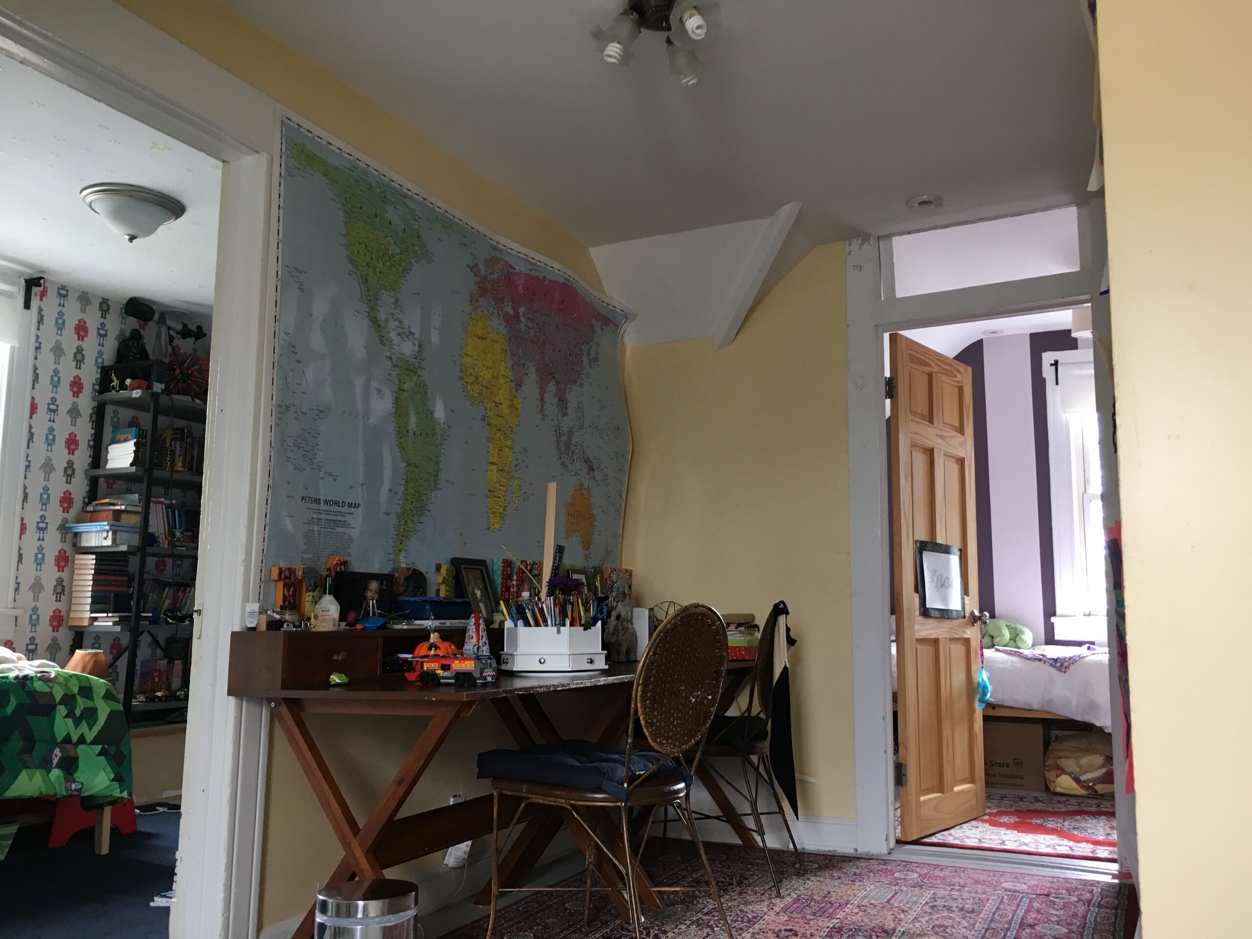 Pre-renovation view of the third-floor hall with dated finishes, showing attic layout before conversion to brighter bedrooms and a master bath.