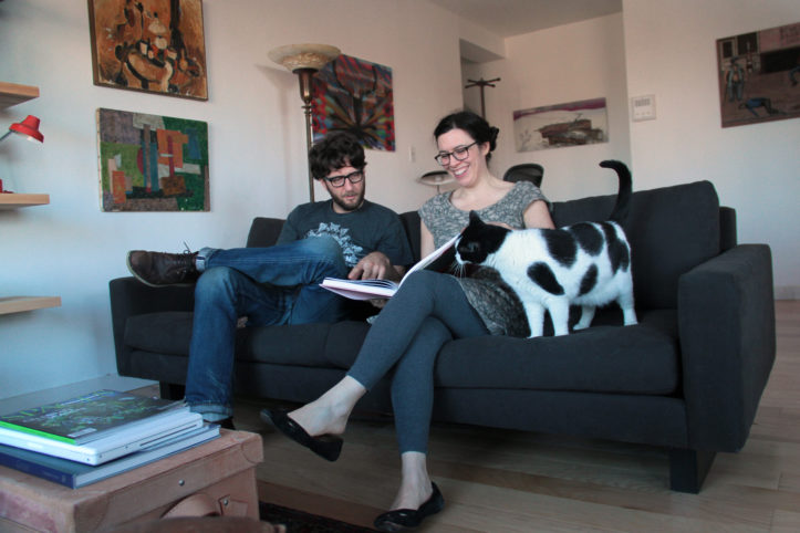 billy and sally on sofa with their cat in their living room after renovation