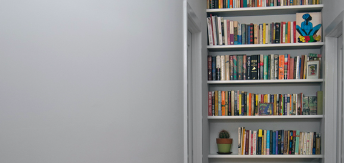 built-in book shelves with white shelves and gray walls after renovation 