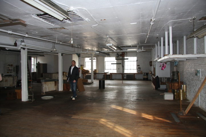 man inspecting a large space to be converted to an apartment or living space before renovation
