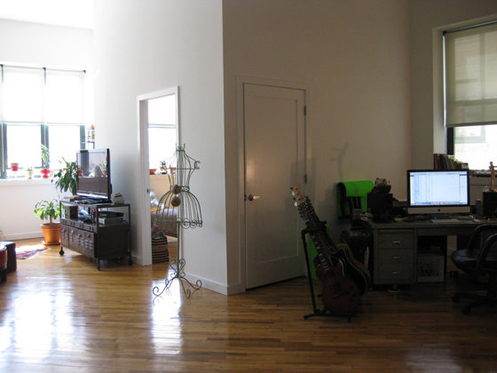 living room with track lights and white walls and hardwood floors and doors after renovation