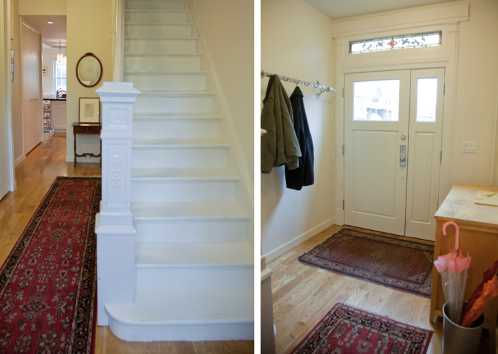hallway with hardwood floors and white staircase and foyer with entryway door after renovation
