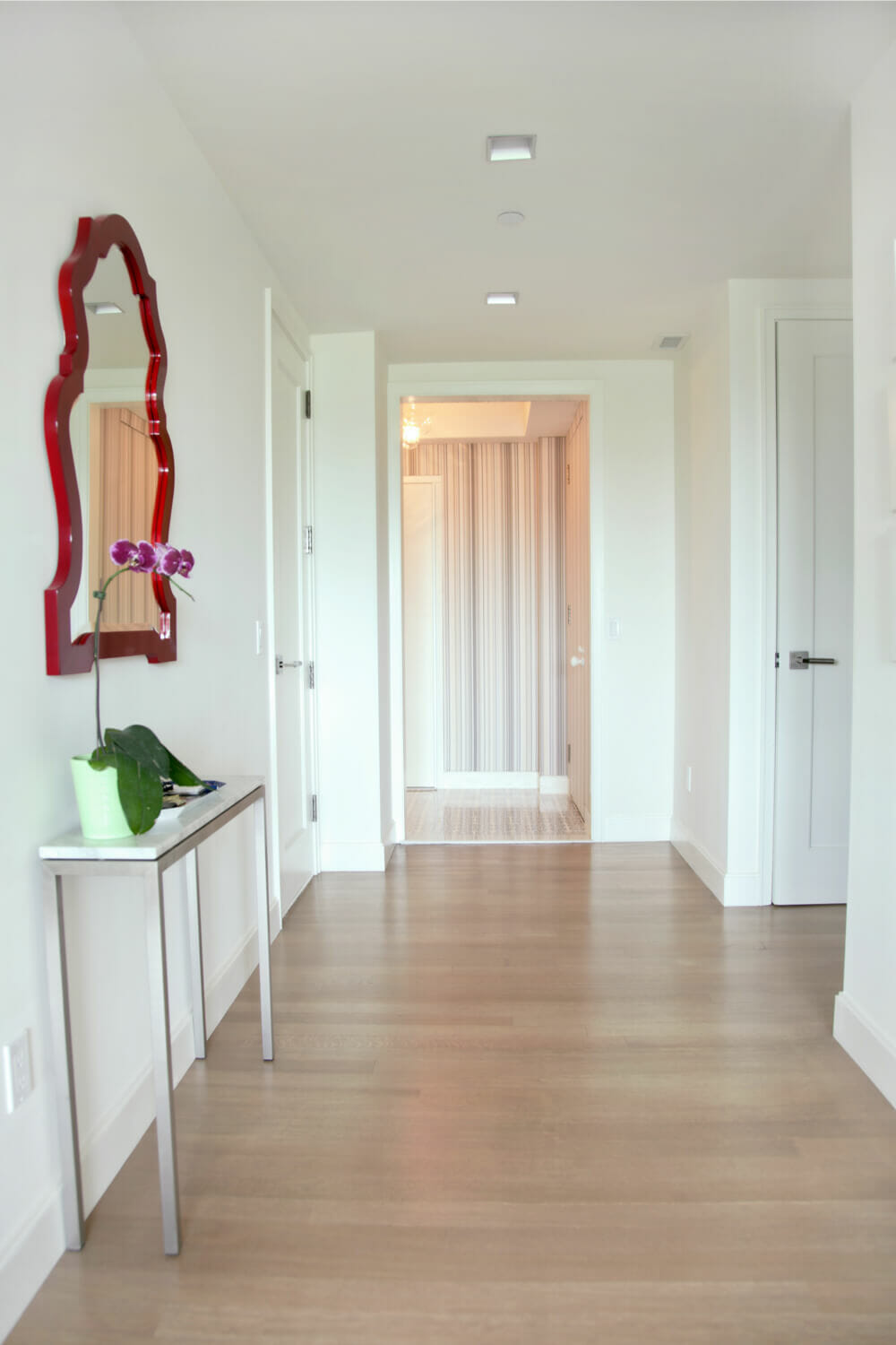 white entry hallway with hardwood floors and recessed lights after renovation
