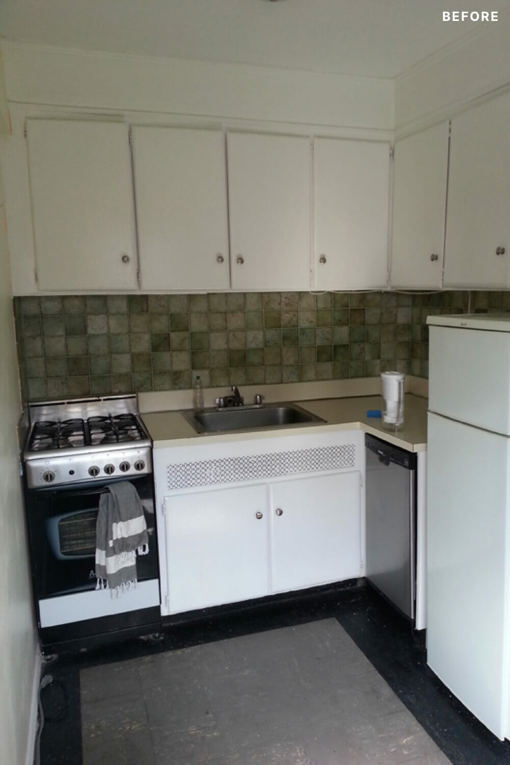 small kitchen with white cabinets and square backsplash tiles and black floor before renovation
