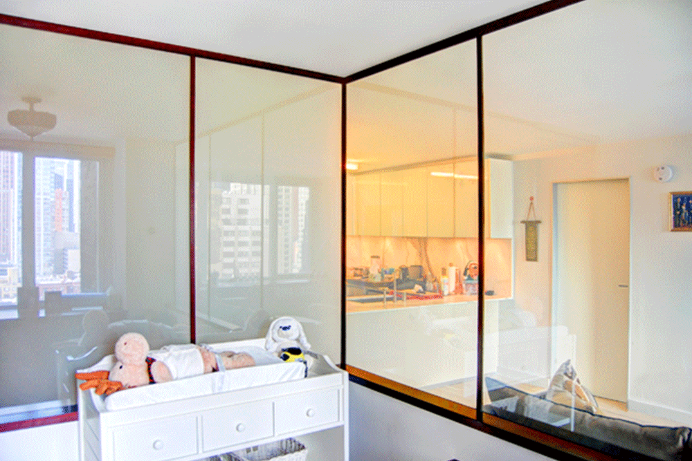 baby room with half glass wall next to the kitchen and living room after renovation