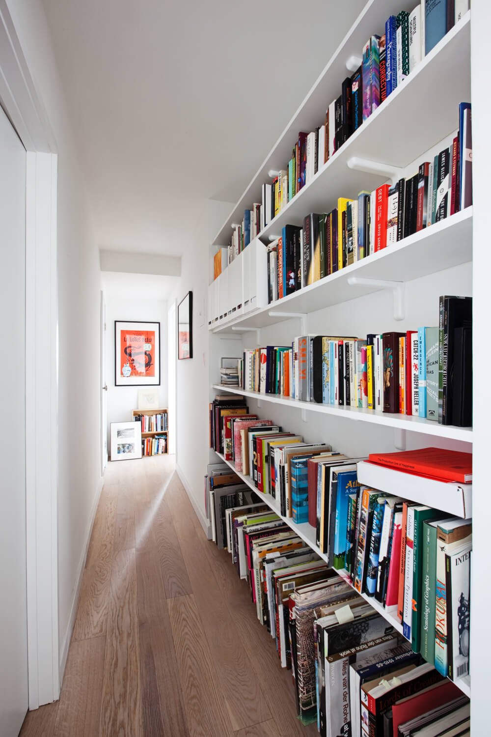 floor to ceiling built in wall book shelves for home library in the hallway after renovation