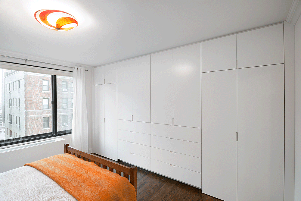 bedroom with hardwood floors and large built-in wardrobes and window with black frames after renovation