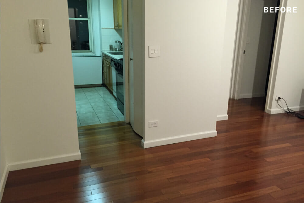 narrow passage to small kitchen and hardwood floors in the living area before renovation