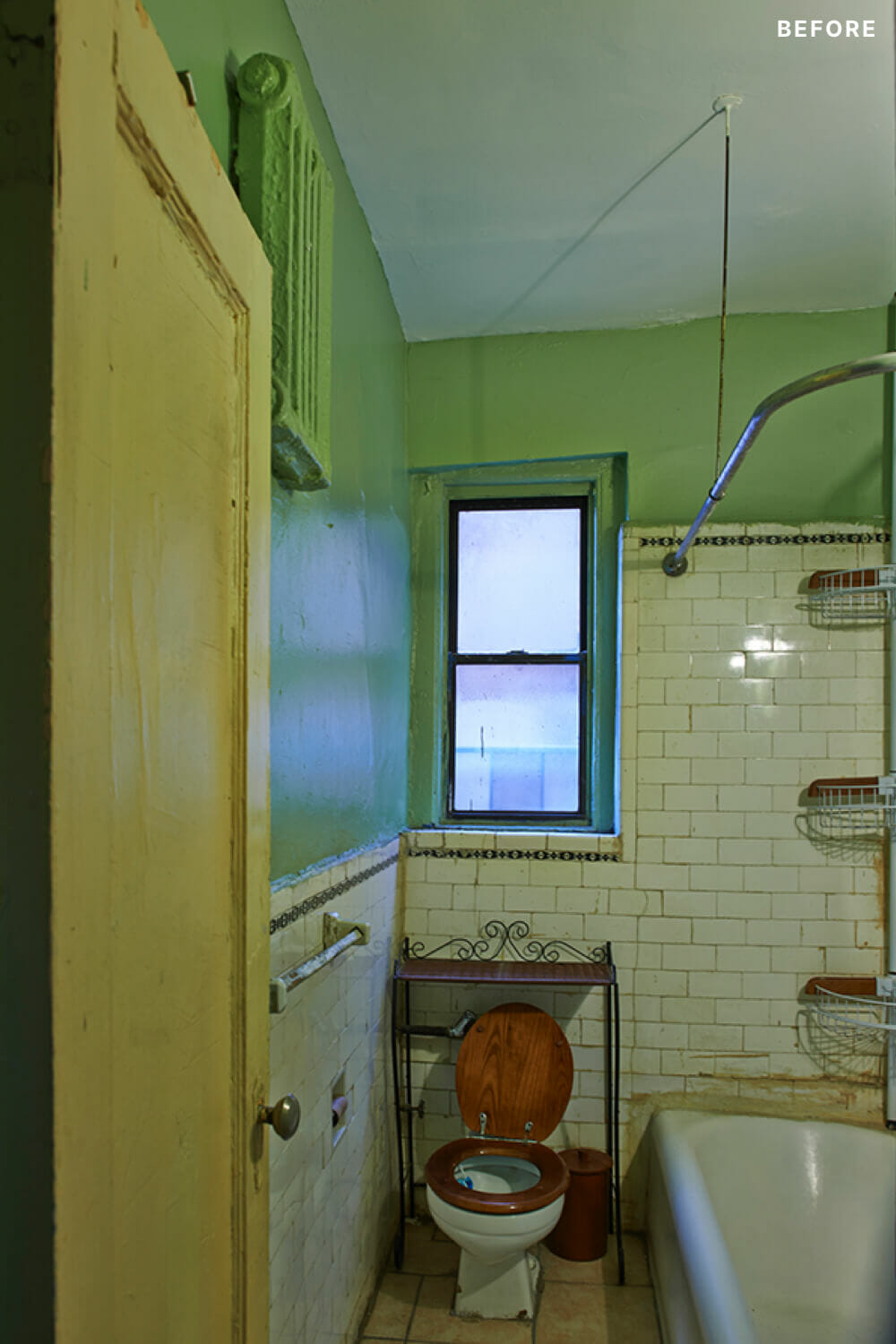 small bathroom with bathtub and wall tiles and green paint before renovation