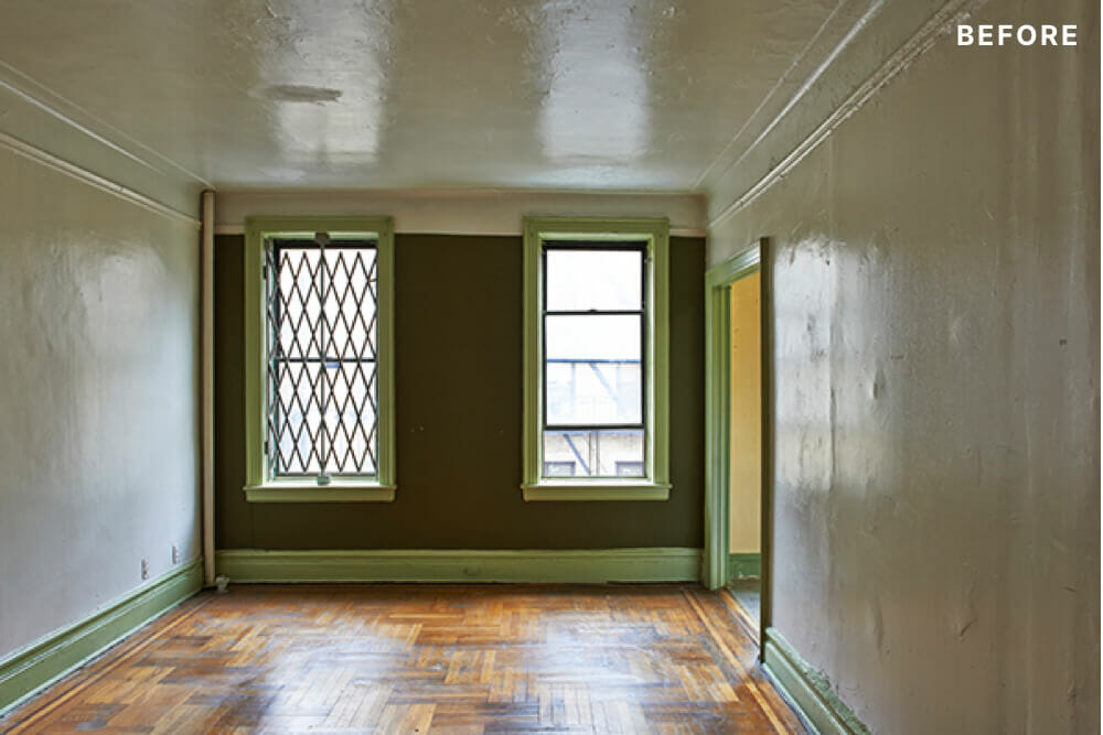 room with stained hardwood flooring and white walls and windows before renovation