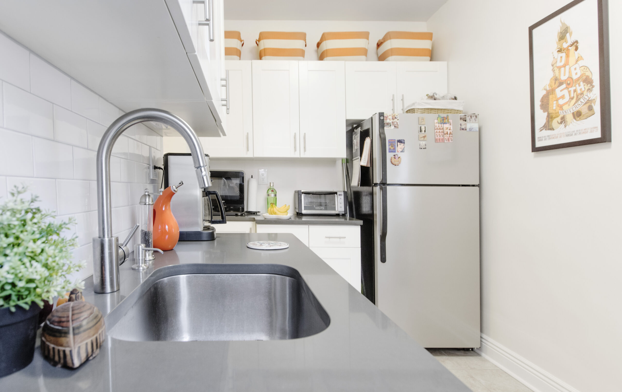 View of an updated kitchen featuring white shaker cabinets, stainless steel appliances, and gray countertops that inspires kitchen renovations in Kensington.