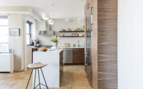 open kitchen with wooden cabinets and stainless steel appliances and parquet flooring and cabinets around refrigerator after renovation