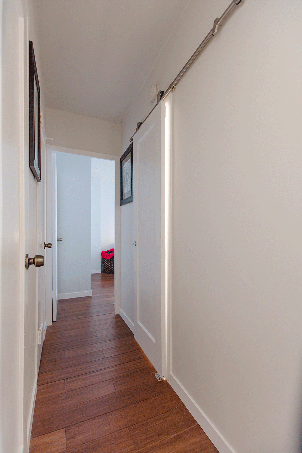 hallway with hardwood floors and white walls after renovation