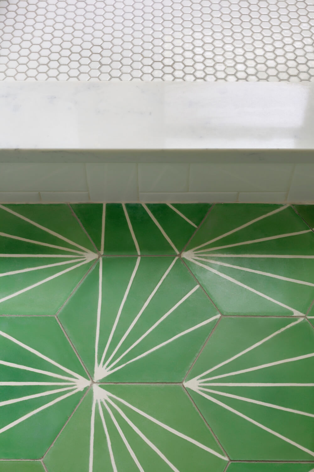 Hex tiles with sunburst patterns and small white hex tiles for walk in shower after renovation