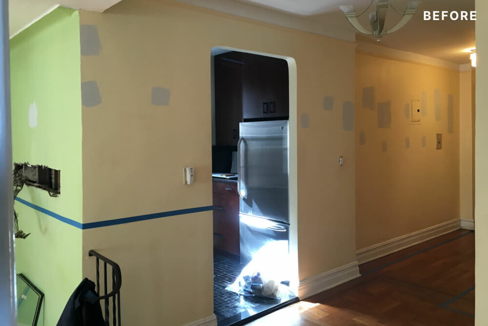Cream walls and entry way to kitchen with view of the entry foyer before renovation