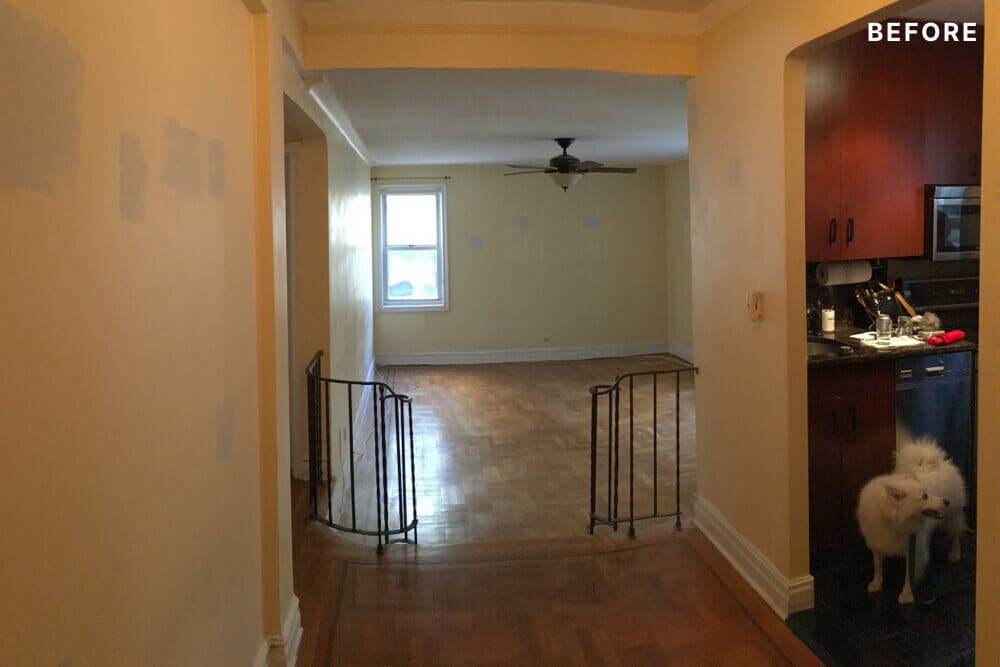 Entry foyer with wooden flooring leading to room and adjacent kitchen before renovation