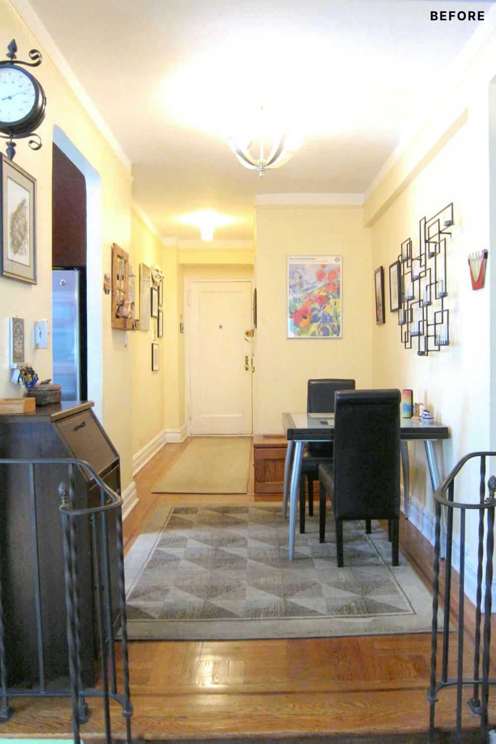 Entryway with white door and two seater dining table and cream walls before renovation