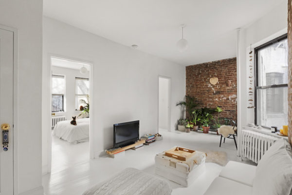 White living room with exposed brick wall