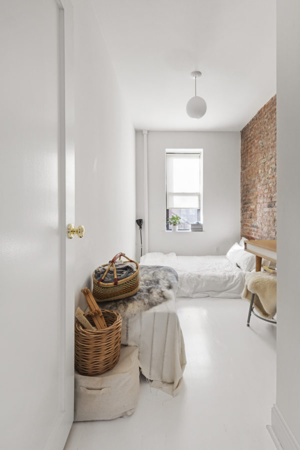 White bedroom with exposed brick wall