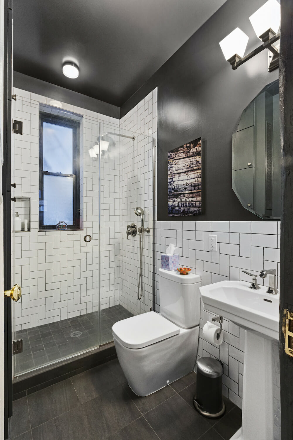 Image of a bathroom with white subway tile in a herringbone pattern