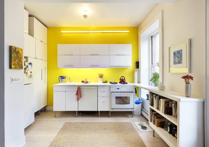 beige kitchen with yellow highlight wall and white kitchen cabinets after renovation