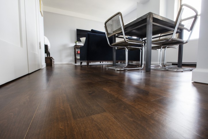 dark brown floor wood for a white and gray room with metal table and chairs after renovation