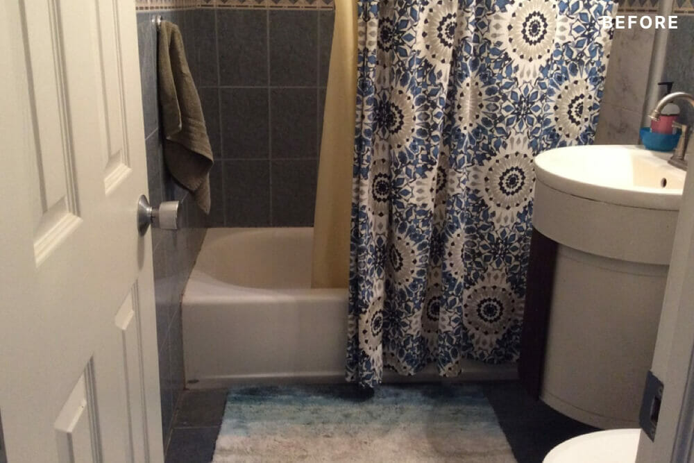 Small bathroom with dark tiles and shower curtains before renovation