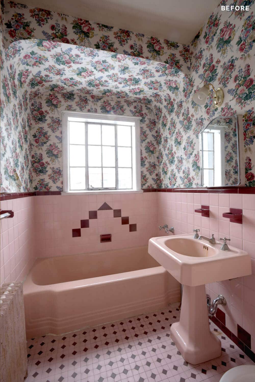 Pink bathroom with pedastal sink along with pink bathtub and floral wallpaper before renovation