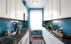 galley kitchen with blue walls and granite countertops