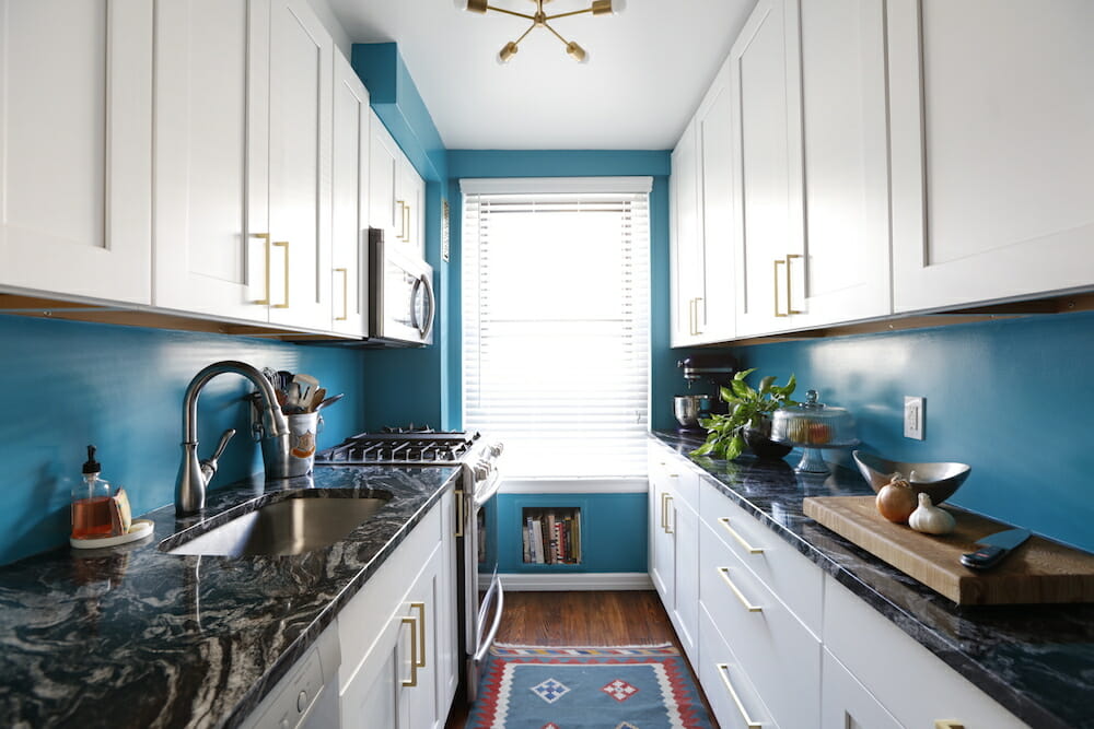 galley kitchen with blue walls and granite countertops