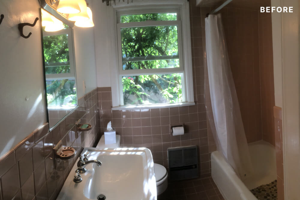 Light biscuit and white bathroom with white tub and pedestal sink and double hung window before renovation
