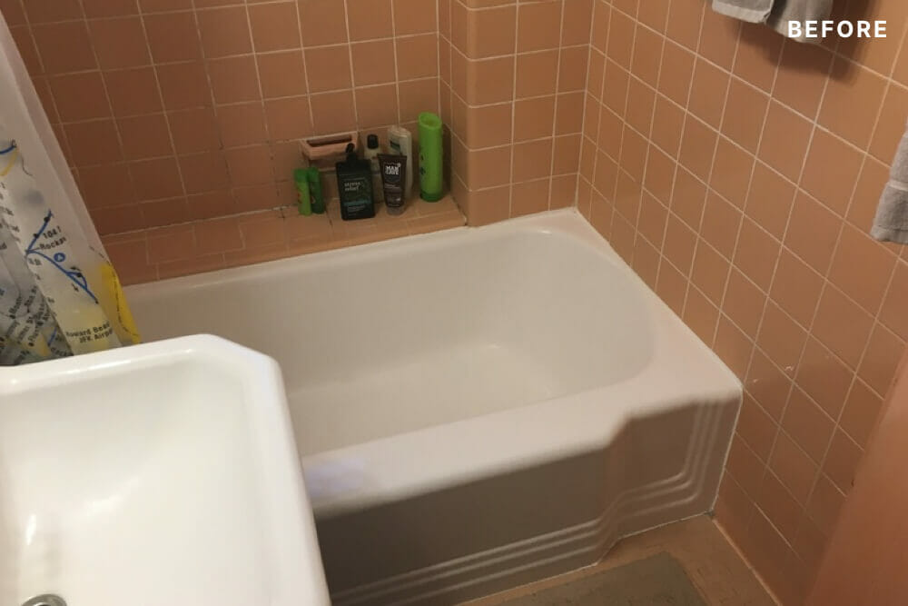 Small orange wall tiles and white bathtub before renovation