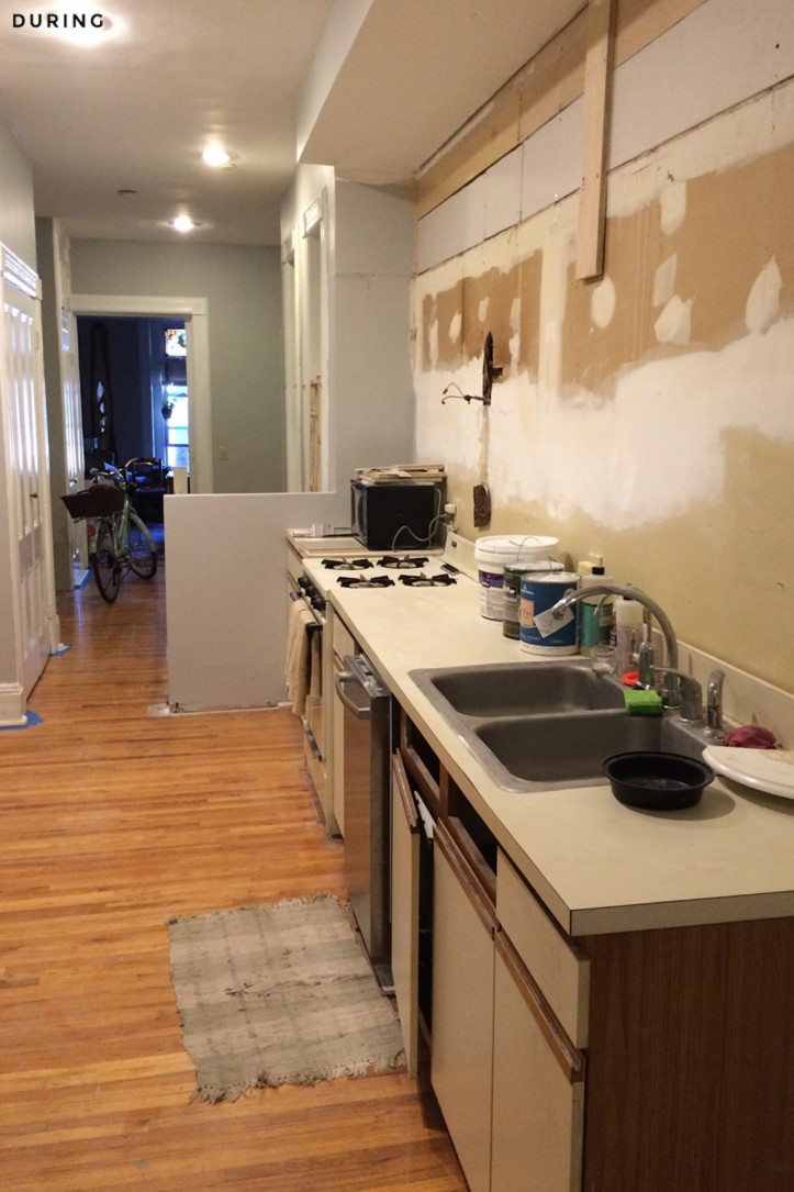 white countertop and kitchen cabinets with brown vinyl floor during renovation