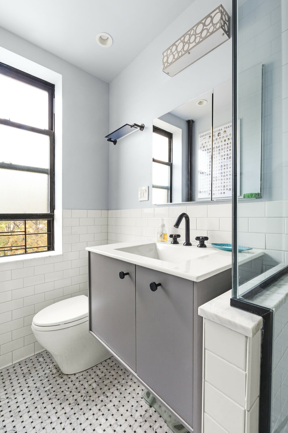 bathroom with basketweave tile floor and floating gray vanity