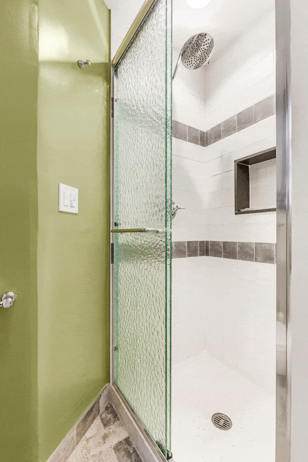 Frosted glass sliding door leading to white shower area after renovation