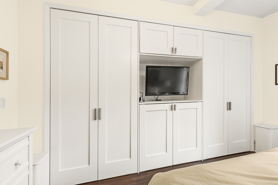 gray closet with handles in bedroom with niche for tv after renovation