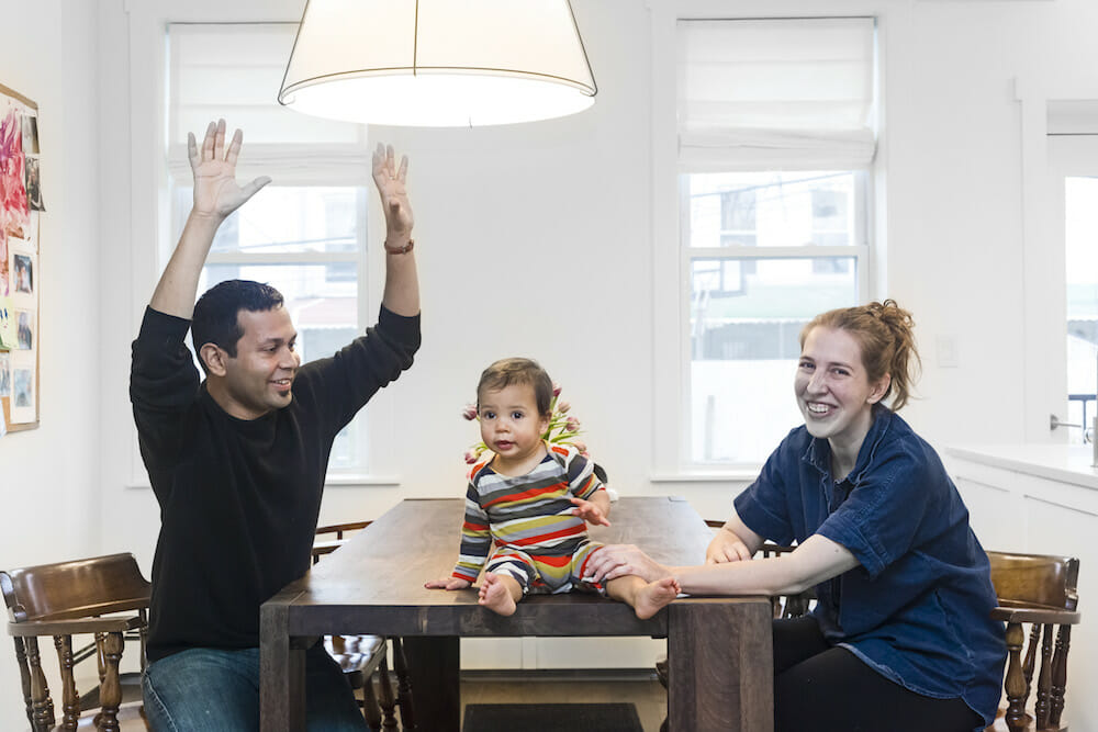 happy homeowners with baby in the dining room and hanging pendent light after renovation