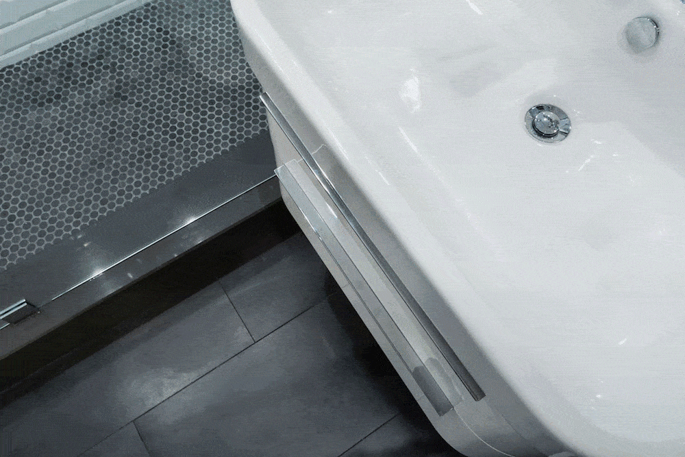 Vanity drawers under white sink and black floor tiles after renovation