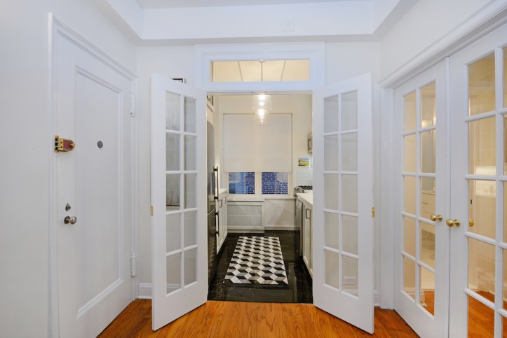 white glass panelled doors to kitchen with brown floor after renovation 