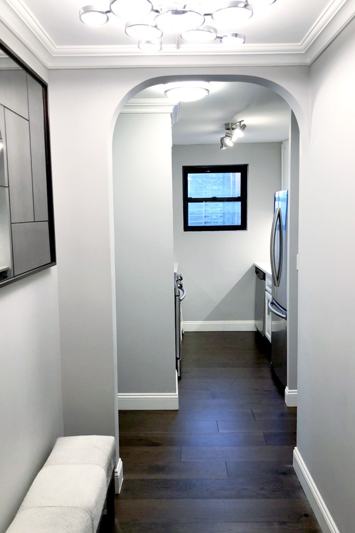 arched entryway with gray walls and pendant lights in the ceiling after renovation 