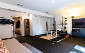 white walls in a home gym with equipments and black floor after renovation