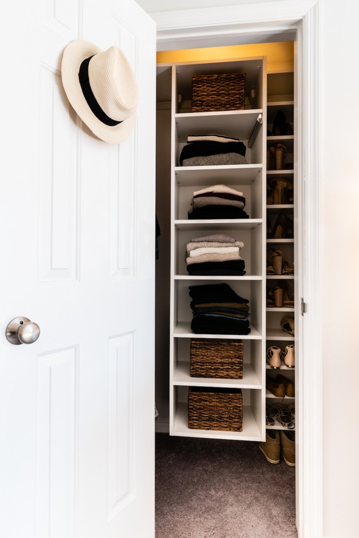 walk in closet with white open shelves for clothes and white door with door knob after renovation  
