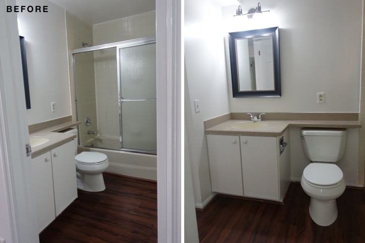white bathroom with white floating vanity and shower doors before renovation
