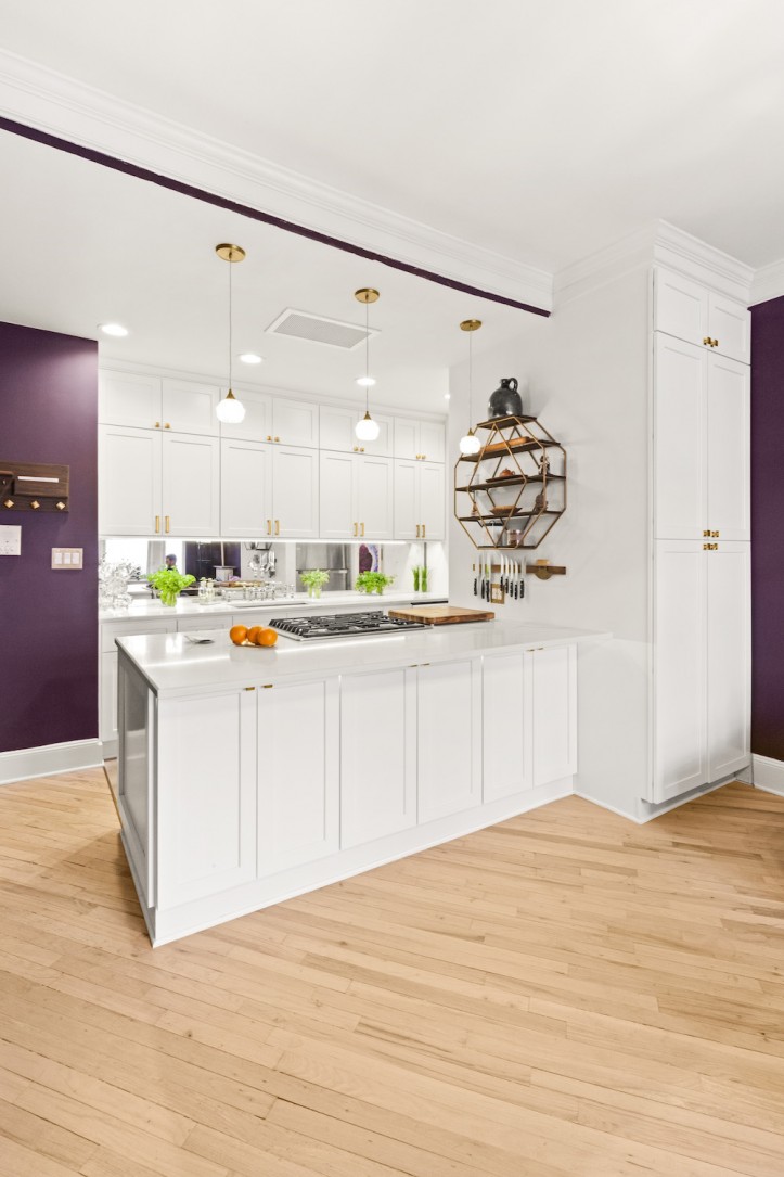 white and purple kitchen with white cabinets and hanging pendant lighting after renovation 