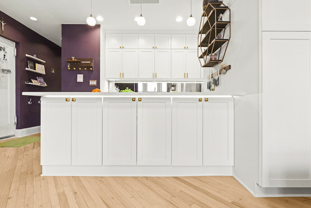 white kitchen peninsula with custom cabinets in open purple and white kitchen