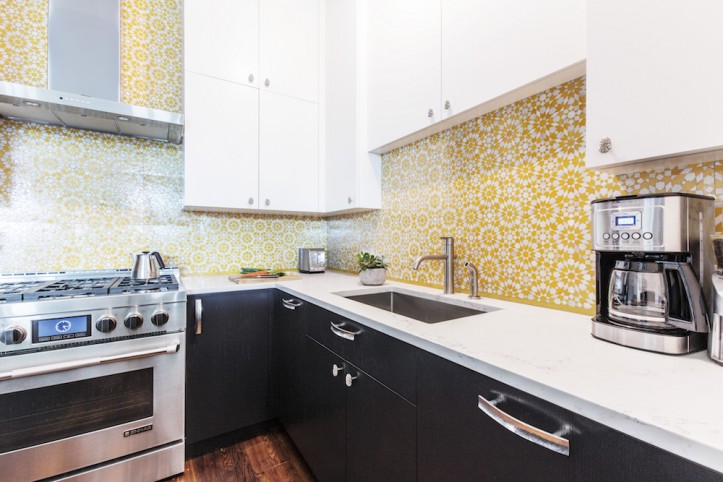 Kitchen counter with white cabinets and yellow kitchen tile backsplash