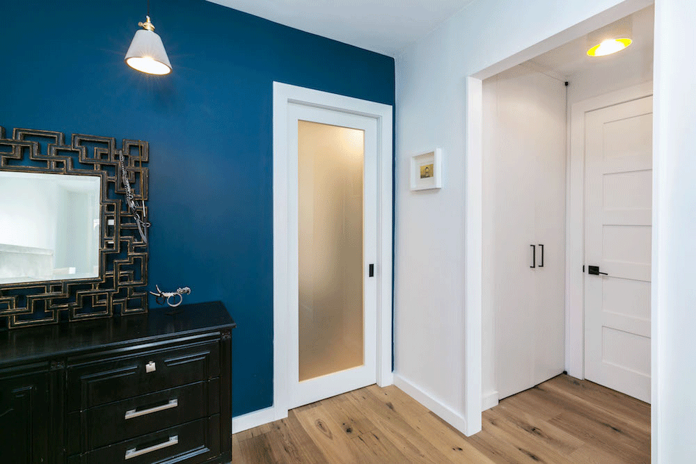 blue wall and a white glass door and light brown floor after renovation