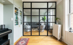 glass enclosure separating living room and den