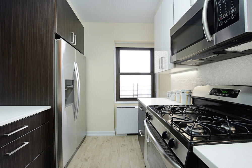 White upper cabinets paired with dark brown cabinets and cooking range and refrigerators after renovation